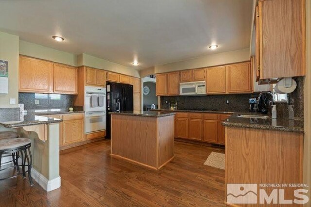 5284 Tappan Ct, Reno, NV 89523 - kitchen featuring white appliances, a sink, decorative backsplash, a kitchen island, and recessed lighting