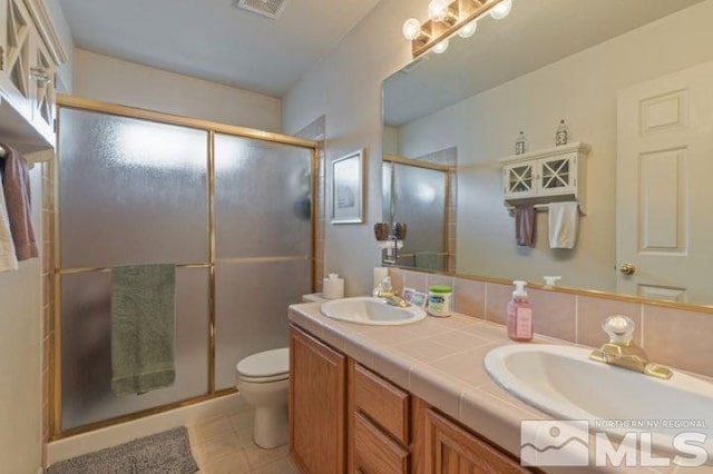 5284 Tappan Ct, Reno, NV 89523 - bathroom with a shower stall, toilet, double vanity, and tile patterned flooring