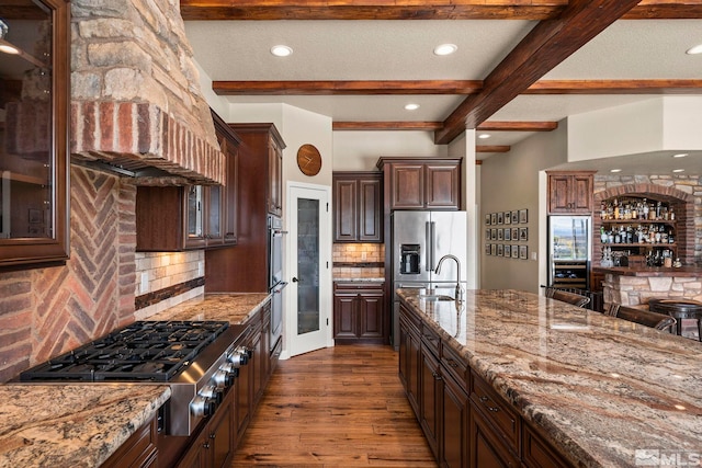9825 Hayfield Dr, Sparks, NV 89441 - kitchen with stainless steel appliances, light stone countertops, beam ceiling, dark wood-style floors, and backsplash