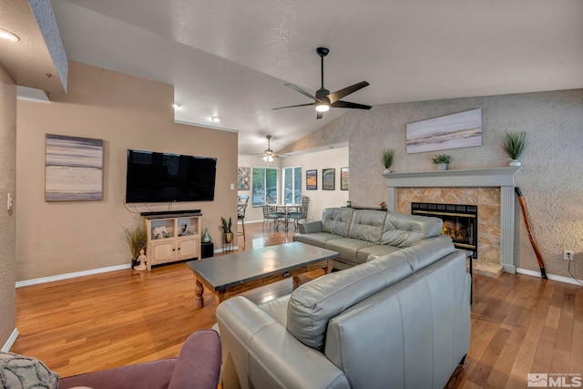 5190 Orinda Dr, Sparks, NV 89436 - living area with vaulted ceiling, baseboards, wood finished floors, a high end fireplace, and a ceiling fan