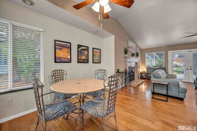 5190 Orinda Dr, Sparks, NV 89436 - dining space featuring a ceiling fan, vaulted ceiling, a tiled fireplace, light wood-type flooring, and baseboards