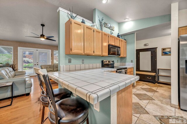 5190 Orinda Dr, Sparks, NV 89436 - kitchen featuring stainless steel appliances, tile countertops, ceiling fan, open floor plan, and a peninsula