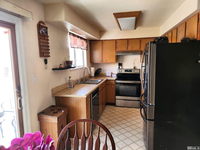17385 Egret Ln, Reno, NV 89508 - kitchen featuring stainless steel appliances, a sink, under cabinet range hood, light countertops, and brown cabinets