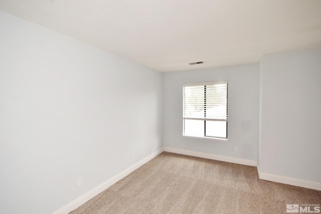unfurnished room with baseboards and light carpet