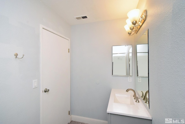 bathroom featuring a chandelier and vanity