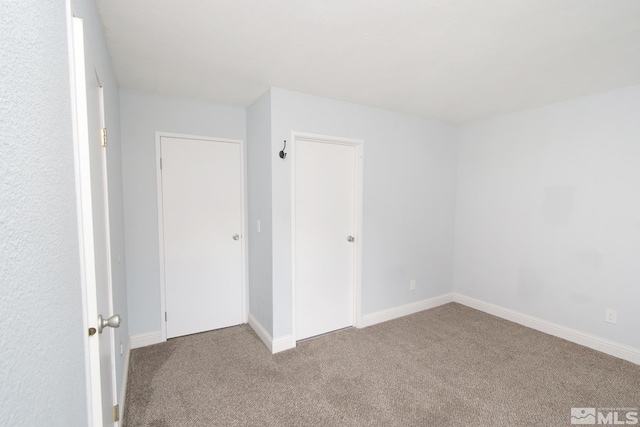 empty room with carpet and baseboards