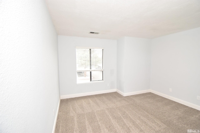 carpeted spare room featuring baseboards