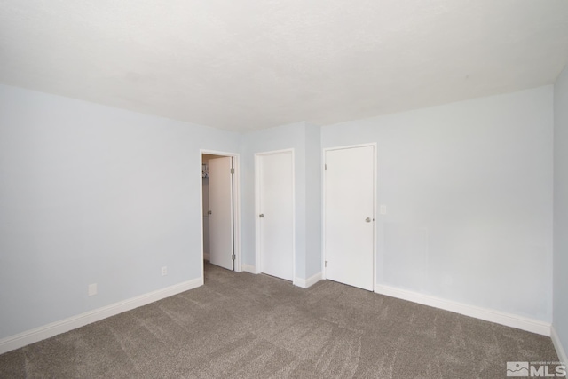 unfurnished bedroom featuring carpet floors and baseboards