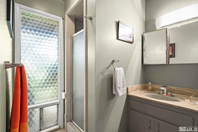 full bathroom featuring a shower stall, plenty of natural light, and vanity