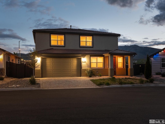 213 Enclave Key Ct, Reno, NV 89506 - traditional home with stucco siding, decorative driveway, an attached garage, a tiled roof, and a mountain view