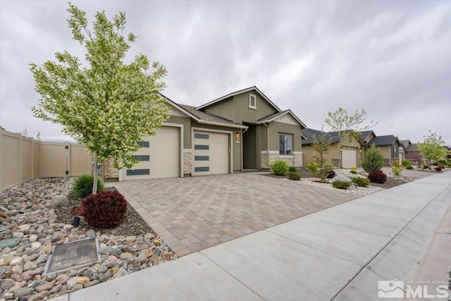 11129 Bandero Heights Ln, Reno, NV 89521 - view of front of home with an attached garage, decorative driveway, stucco siding, stone siding, and fence