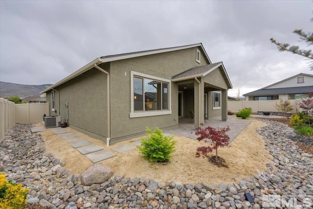 11129 Bandero Heights Ln, Reno, NV 89521 - view of front of home featuring a patio area, a fenced backyard, stucco siding, and central AC unit
