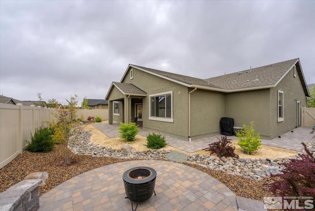 11129 Bandero Heights Ln, Reno, NV 89521 - rear view of property with a patio, a fenced backyard, an outdoor fire pit, stucco siding, and a shingled roof