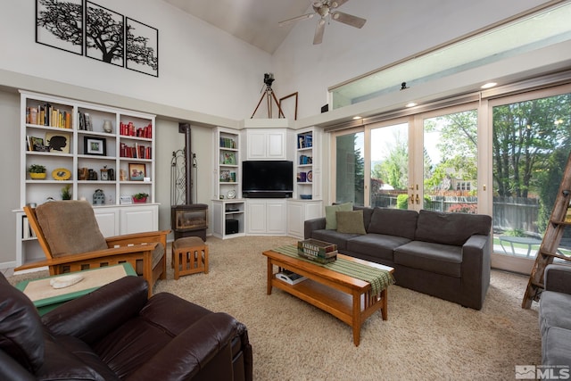 971 Fieldgate Way, Gardnerville, NV 89460 - living room featuring high vaulted ceiling, light colored carpet, a ceiling fan, a wood stove, and french doors