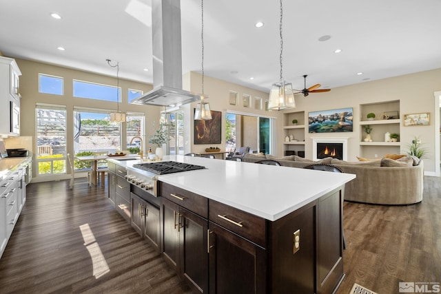 1009 Tremolite, Reno, NV 89511 - kitchen featuring stainless steel gas cooktop, island exhaust hood, a ceiling fan, a lit fireplace, and light countertops