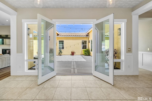 1009 Tremolite, Reno, NV 89511 - doorway to outside featuring french doors, tile patterned flooring, wainscoting, and a decorative wall