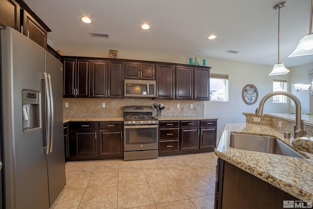 6680 Voyage Dr, Sparks, NV 89436 - kitchen with appliances with stainless steel finishes, a sink, decorative backsplash, dark brown cabinetry, and recessed lighting