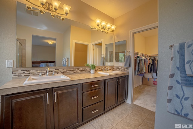 6680 Voyage Dr, Sparks, NV 89436 - bathroom featuring a chandelier, tile patterned floors, a walk in closet, and tasteful backsplash