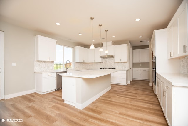 620 Sage Grouse Lp, Gardnerville, NV 89460 - kitchen with stainless steel appliances, a kitchen island, light wood-style flooring, decorative backsplash, and white cabinets
