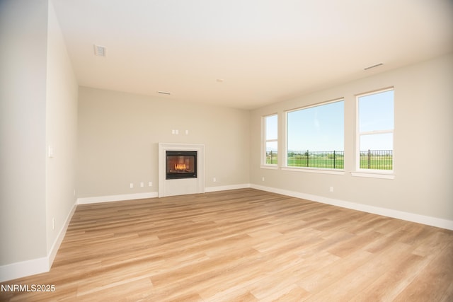 620 Sage Grouse Lp, Gardnerville, NV 89460 - unfurnished living room with light wood finished floors, a glass covered fireplace, and baseboards
