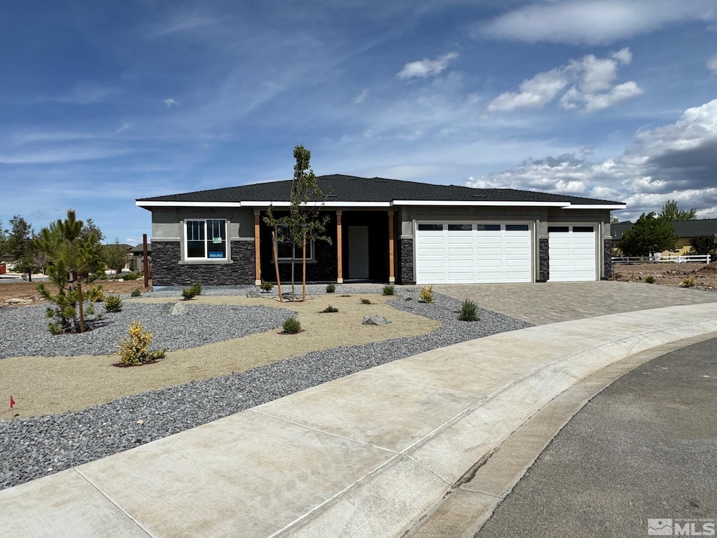 638 Sage Grouse Loop, Gardnerville, NV 89460 - view of front of home featuring stone siding, decorative driveway, and an attached garage