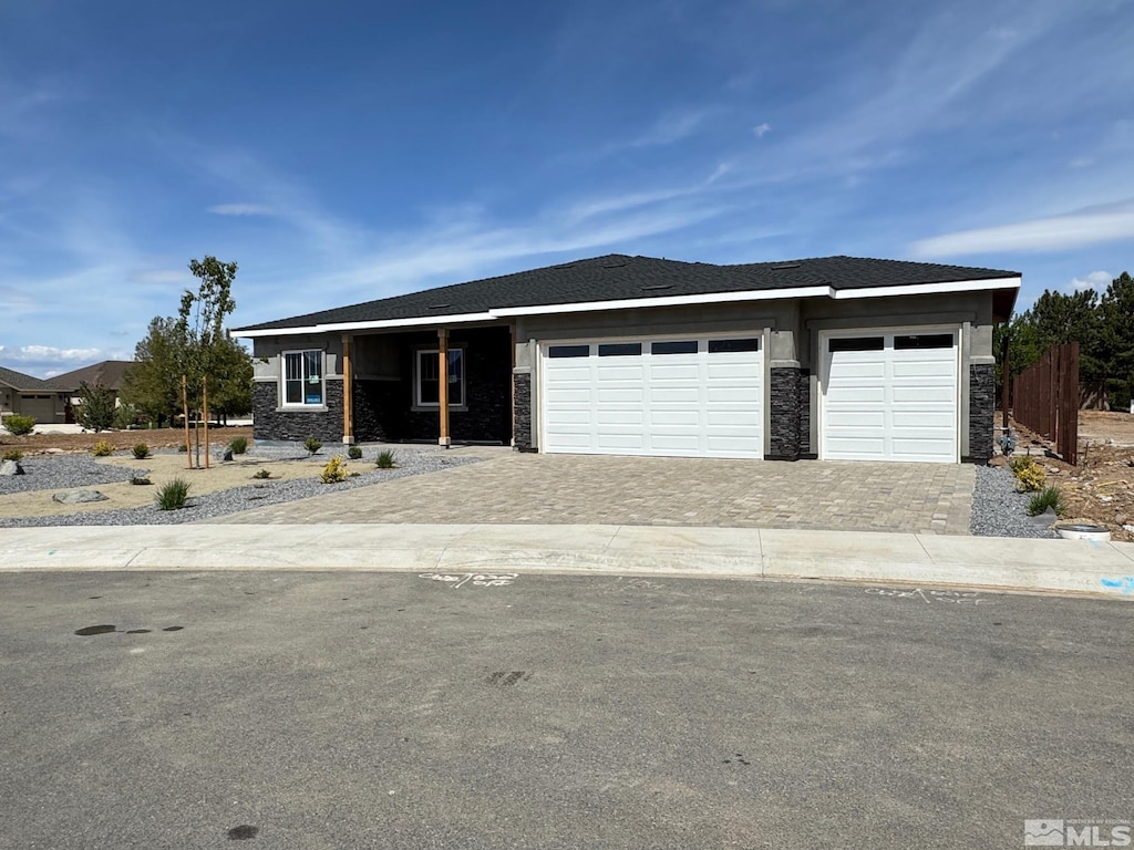638 Sage Grouse Loop, Gardnerville, NV 89460 - view of front of home with stone siding, decorative driveway, an attached garage, and fence