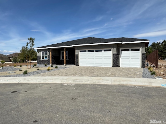 638 Sage Grouse Loop, Gardnerville, NV 89460 - view of front of home with stone siding, decorative driveway, an attached garage, and fence