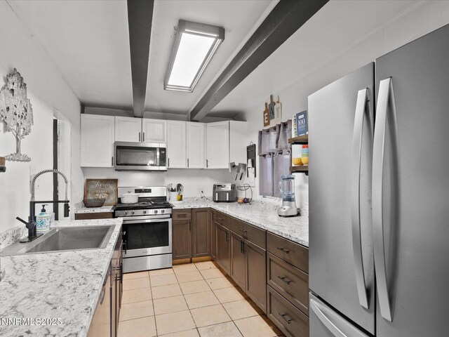 665 Southworth Dr, Reno, NV 89512 - kitchen with stainless steel appliances, a sink, white cabinets, beamed ceiling, and light tile patterned floors