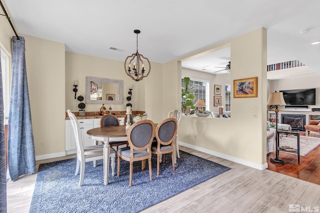 2374 Roman Dr, Sparks, NV 89434 - dining room with light wood-style flooring, a chandelier, a ceiling fan, and baseboards