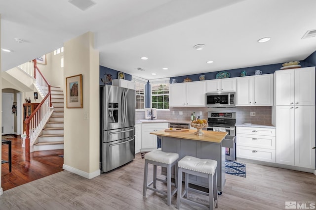 2374 Roman Dr, Sparks, NV 89434 - kitchen with appliances with stainless steel finishes, butcher block countertops, white cabinets, a sink, and decorative backsplash