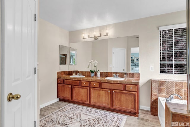 2374 Roman Dr, Sparks, NV 89434 - ensuite bathroom with wood finished floors, double vanity, a bath, and baseboards