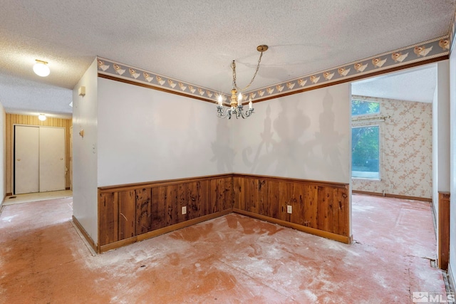 966 Woodstone Dr, Sparks, NV 89434 - unfurnished dining area with a textured ceiling, a wainscoted wall, a chandelier, unfinished concrete floors, and wooden walls