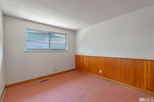 966 Woodstone Dr, Sparks, NV 89434 - empty room featuring a wainscoted wall, a textured ceiling, wood walls, and carpet