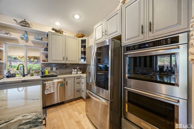 6525 Monticello Ct, Reno, NV 89519 - kitchen with appliances with stainless steel finishes, a sink, light wood-style flooring, backsplash, and healthy amount of natural light
