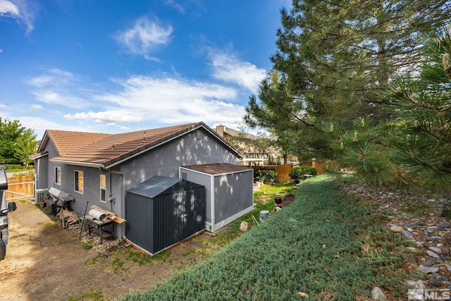 6525 Monticello Ct, Reno, NV 89519 - view of home's exterior with a shed, an outdoor structure, a tile roof, and stucco siding