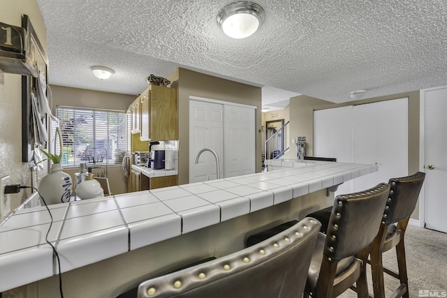 1064 Bradley Sq, Sparks, NV 89434 - kitchen with tile countertops, a textured ceiling, light carpet, and a sink