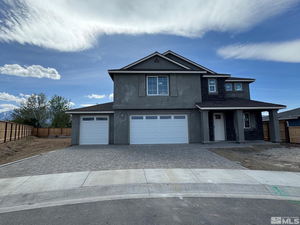 692 Sage Grouse Loop, Gardnerville, NV 89460 - view of front of home with driveway, fence, an attached garage, stucco siding, and covered porch