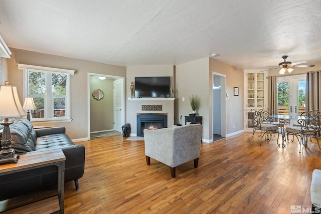 2066 Plumas St, Reno, NV 89509 - living room featuring ceiling fan, a fireplace with flush hearth, light wood finished floors, baseboards, and a textured ceiling