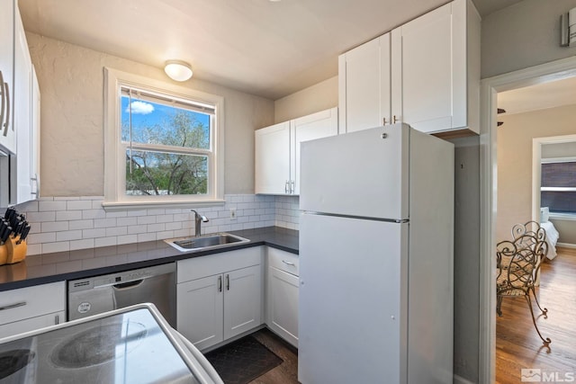 2066 Plumas St, Reno, NV 89509 - kitchen with freestanding refrigerator, a sink, dark countertops, stainless steel dishwasher, and decorative backsplash