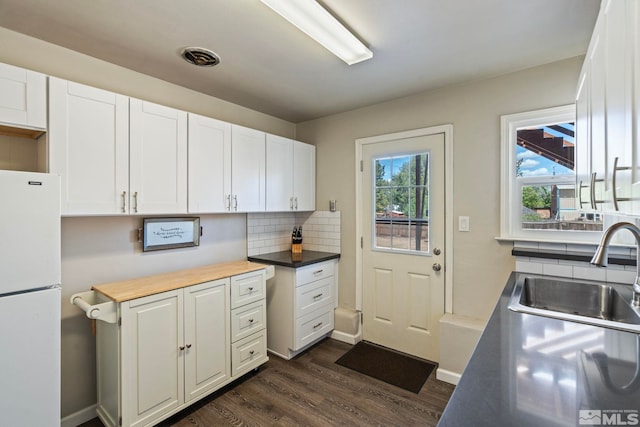 2066 Plumas St, Reno, NV 89509 - kitchen with freestanding refrigerator, a sink, dark wood-style flooring, decorative backsplash, and white cabinets