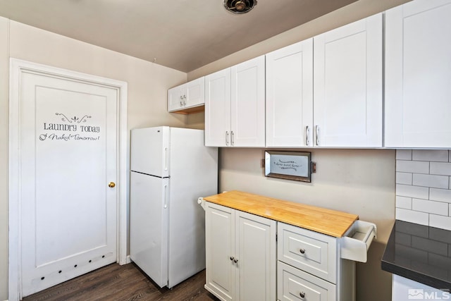2066 Plumas St, Reno, NV 89509 - kitchen featuring freestanding refrigerator, dark wood-style floors, white cabinets, tasteful backsplash, and wood counters