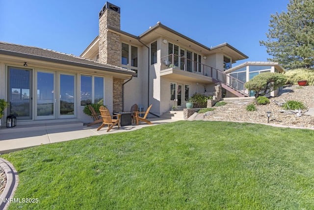 10286 Morning Song Trl, Reno, NV 89511 - back of property with a chimney, stairway, stucco siding, a lawn, and a patio