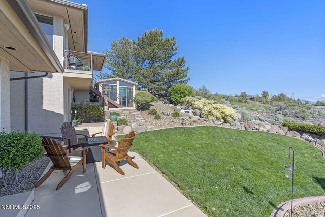 10286 Morning Song Trl, Reno, NV 89511 - view of grassy yard featuring a patio area, a fire pit, and a balcony