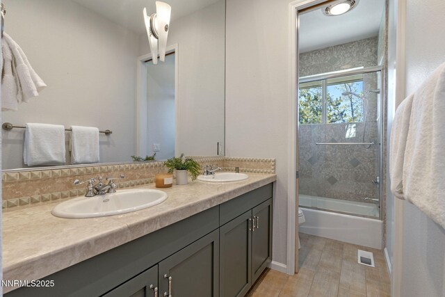 10286 Morning Song Trl, Reno, NV 89511 - full bathroom featuring double vanity, enclosed tub / shower combo, toilet, and tasteful backsplash