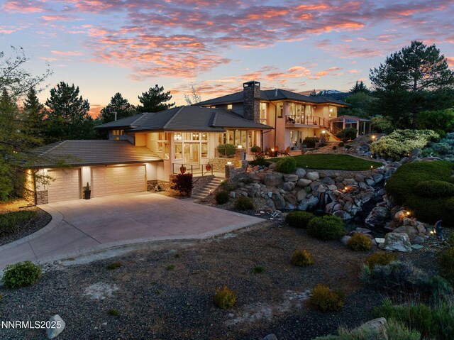 10286 Morning Song Trl, Reno, NV 89511 - view of front of property with a chimney, stairway, an attached garage, concrete driveway, and stucco siding
