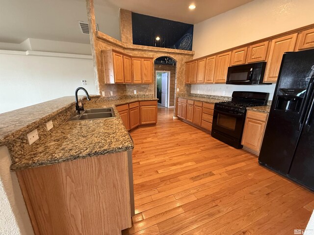 5740 Sarah Rd, Fallon, NV 89406 - kitchen featuring black appliances, a sink, a high ceiling, light wood finished floors, and a peninsula