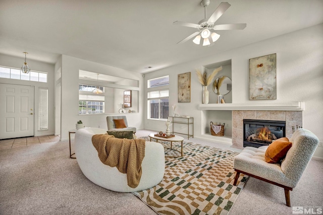 carpeted living room featuring a fireplace and a ceiling fan