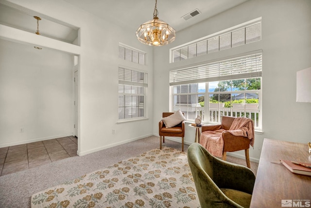 living area featuring a chandelier, carpet floors, baseboards, and a towering ceiling
