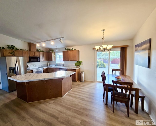 961 Ruddy Ct, Sparks, NV 89441 - kitchen featuring stainless steel refrigerator with ice dispenser, black microwave, electric stove, tile countertops, and a chandelier