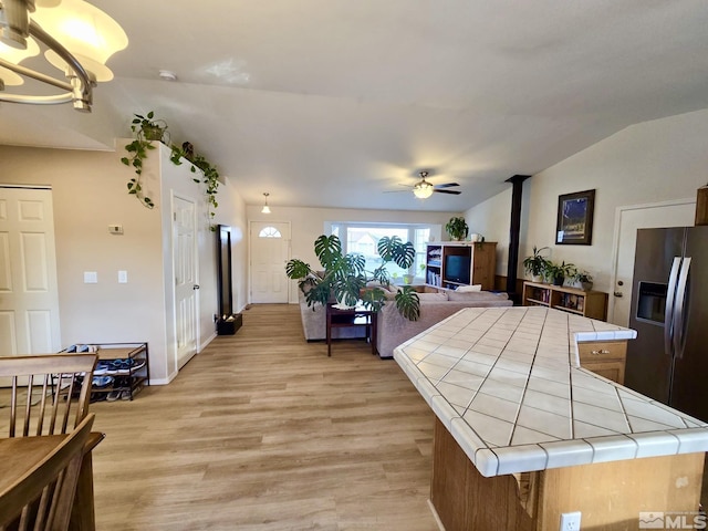 961 Ruddy Ct, Sparks, NV 89441 - kitchen with tile countertops, vaulted ceiling, light wood-style floors, ceiling fan, and stainless steel fridge with ice dispenser